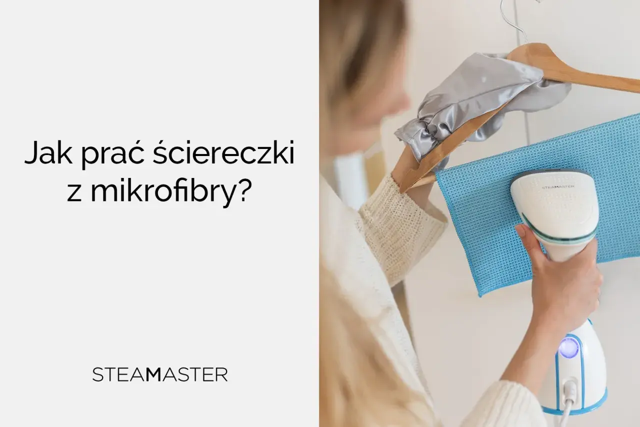 Jak prać ściereczki z mikrofibry? Kobieta używa parownicy Steamaster do odświeżenia niebieskiej ściereczki z mikrofibry wiszącej na wieszaku.