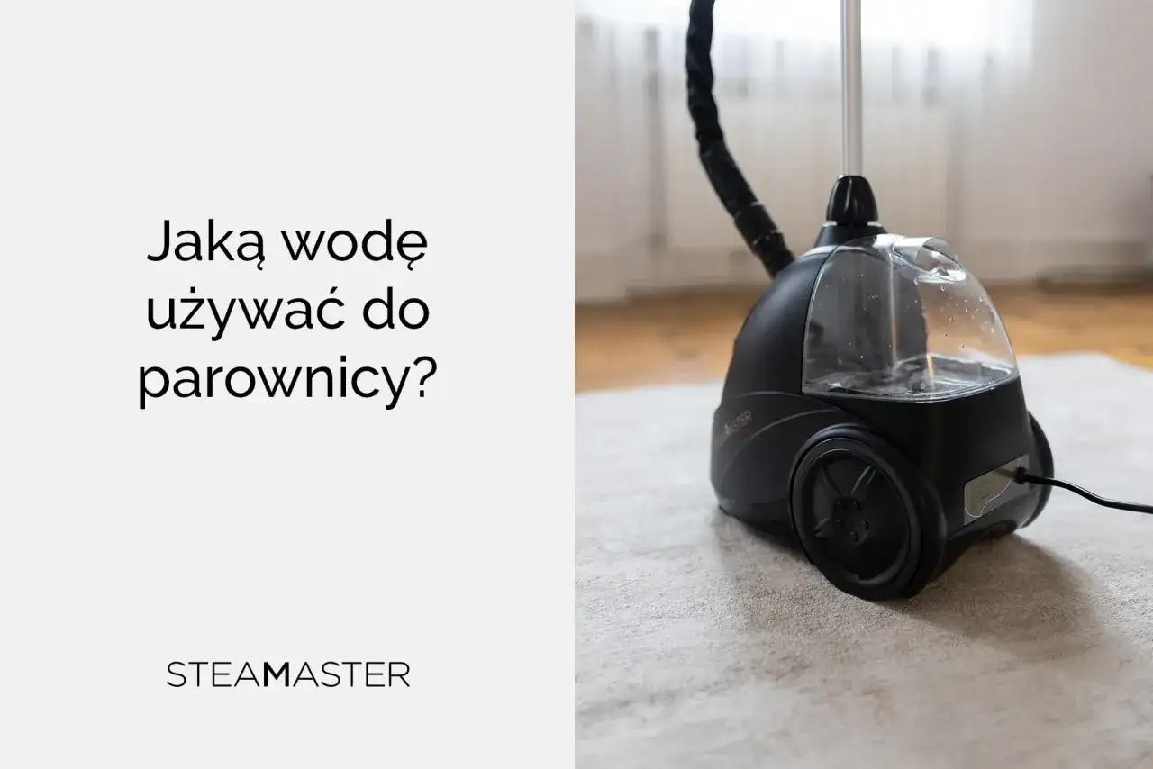 Jaka woda do parownicy? Czarna parownica Steam Master z przezroczystym zbiornikiem na wodę, stojąca na jasnym dywanie.